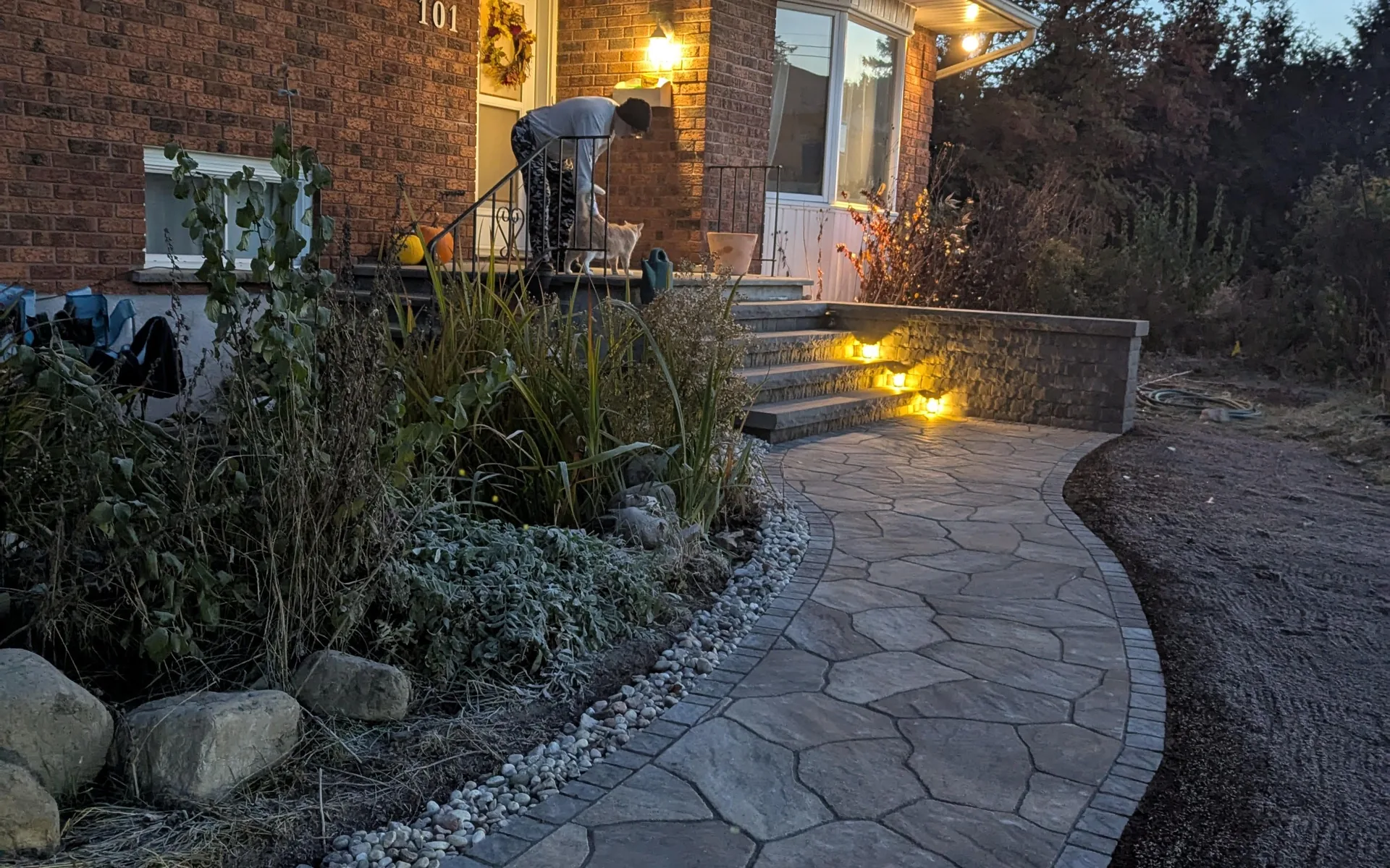 Flagstone walkway and landscape lighting installed by WcStoneworks at dusk